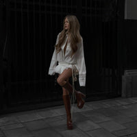 Robe courte blanche plissée, décolleté col en V, manches longues et taille nouée