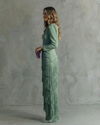Robe vert clair de profil, manches longues bouffantes et jupe à franges en cascade.