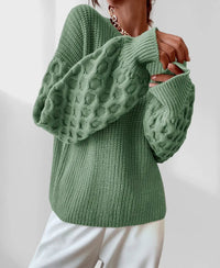 Pull de printemps vert, maille en relief sur les manches, col rond et poignets côtelés.