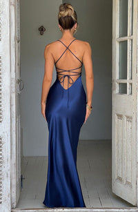 Robe longue en satin bleu dos nu à bretelles croisées, fente sur la jambe.