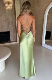 Robe longue en satin vert clair, dos nu à bretelles croisées, fente latérale.