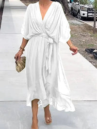 Robe midi blanche à col en V, manches volantées, ceinture nouée, tissu léger fluide.