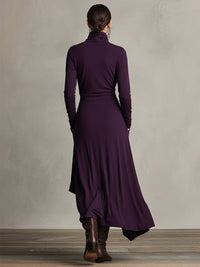 Robe violette drapée vue de dos, encolure haute, jupe évasée et pans flottants