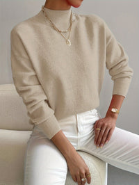 Pull minimaliste beige en maille, encolure ronde, manches longues côtelées.