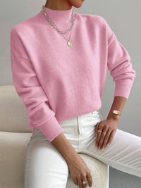 Pull minimaliste rose clair en maille, encolure ronde, manches longues côtelées.