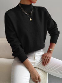 Pull minimaliste noir en maille, encolure ronde, manches longues côtelées.