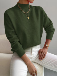 Pull minimaliste vert foncé en maille, encolure ronde, manches longues côtelées.