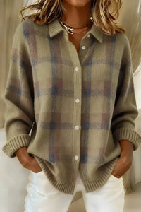 Gilet long en maille gris clair et bleu à carreaux, col avec boutons blancs, bords côtelés.