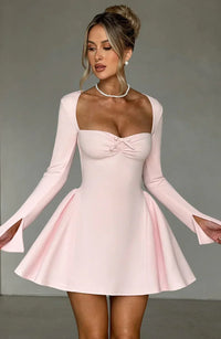 Robe courte trapèze rose pâle, buste froncé en encolure cœur, manches longues