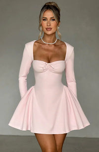 Robe courte trapèze rose pâle, buste froncé, manches longues et jupe évasée