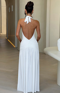 Robe longue blanche dos nu, dos drapé, nœud au cou, jupe fluide avec fronces.