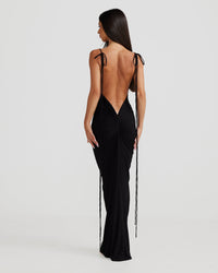 Robe longue noire vue de dos, bretelles nouées et drapés verticaux.