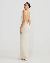 Robe longue blanche à dos nu, bretelles fines et liens noués au dos.