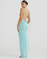 Robe longue bleu clair à dos nu, bretelles nouées avec franges décoratives.