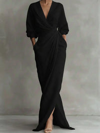 Robe élégante noire drapée, col V, manches bouffantes, fente sur le côté.