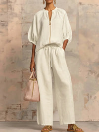 Ensemble chemise et pantalon ample blanc cassé, fermeture zippée, manches bouffantes.