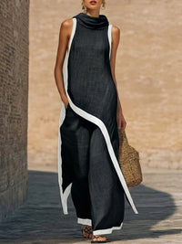 Robe longue sans manches en coton-lin noir, encolure drapée et liseré blanc contrastant.