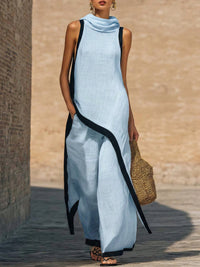 Robe longue sans manches en coton-lin bleu clair, encolure drapée et liseré noir contrastant.