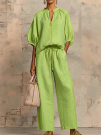 Ensemble chemise et pantalon ample vert clair, fermeture zippée, manches bouffantes.