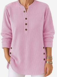 Pull boutonné en maille côtelée rose, encolure ronde, manches longues.