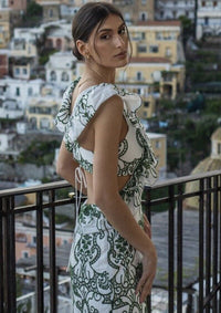 Robe longue verte imprimée, dos échancré avec ruban à nouer et volants d’épaule.