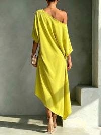 Robe asymétrique jaune, dos dégagé, manches chauve-souris, longueur midi.