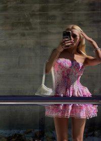 Robe bustier courte rose fleurie, jupe à volants et finitions dentelle au bas