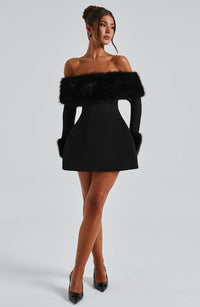 Robe courte noire à épaules dénudées, bandeau de fausse fourrure et jupe évasée.