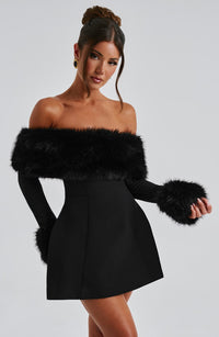 Robe courte noire à épaules dénudées, buste avec fausse fourrure et manches en fourrure.
