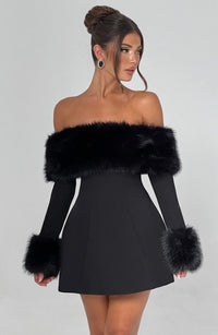 Robe courte noire à épaules dénudées, bandeau et manches en fausse fourrure noire.
