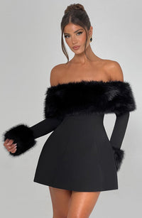 Robe courte noire épaules dénudées, haut en fausse fourrure et manches longues assorties.