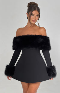 Robe courte noire à épaules dénudées avec bandeau de fausse fourrure et empiècements aux poignets.